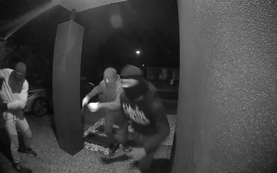 Security footage showing masked people outside a front door